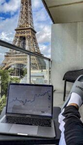 Laptop Lifestyle Solutions-person relaxing in slippers shoes after working on his online business looking at the Eiffel Tower in Paris.